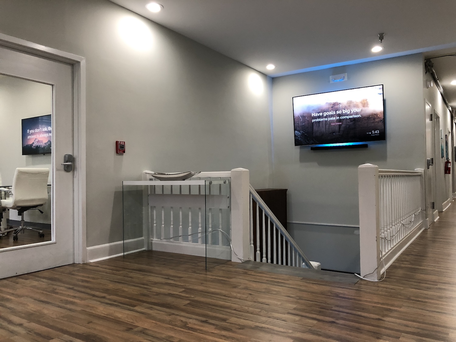 Upstairs landing with a wall-mounted screen next to a conference room