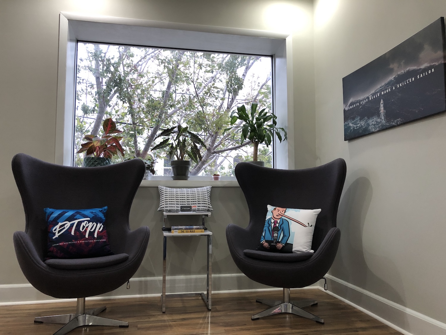 Two lounge chairs by a window, one with a DTopp pillow